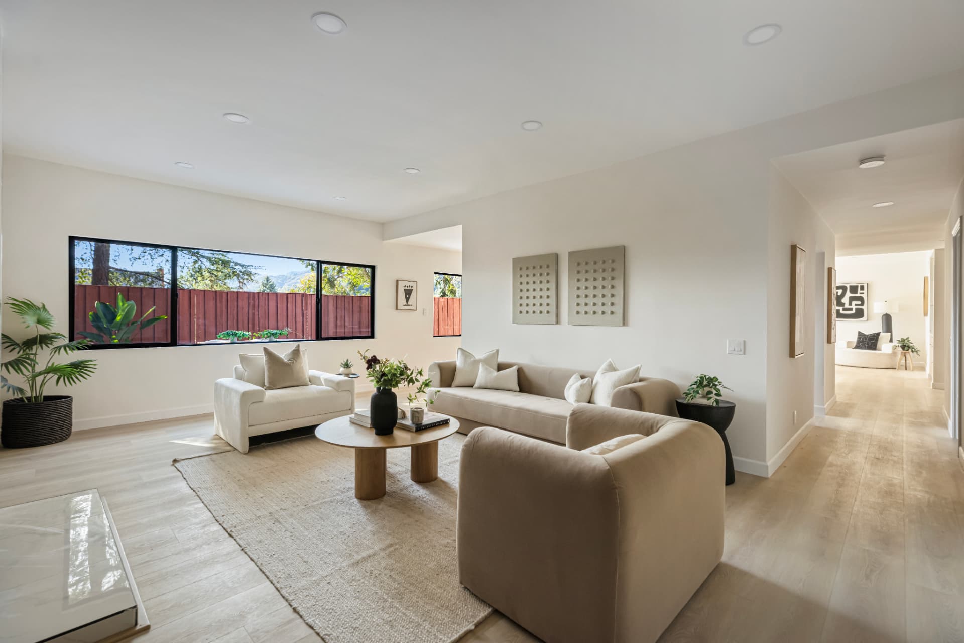 Open living room with a long window wall looking out to trees and mountains